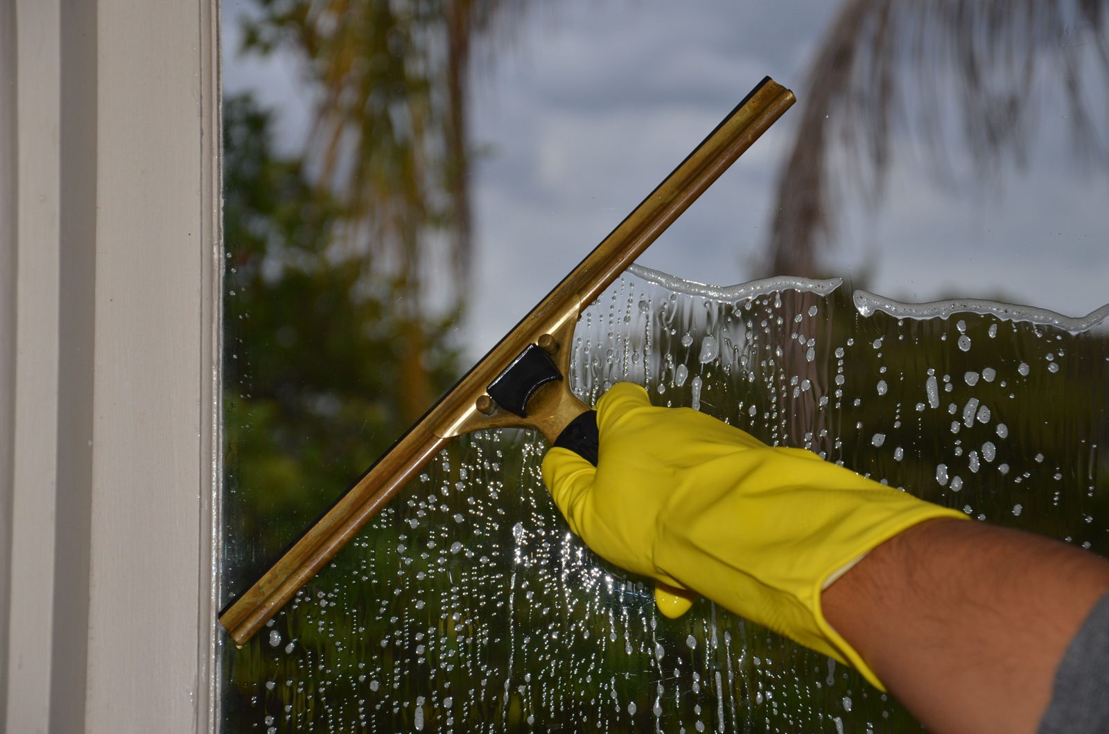 Squeegee clearing soapy water from a window